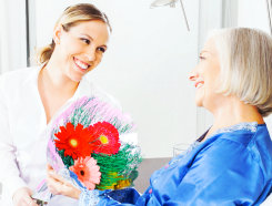 caregiver giving senior woman a flower