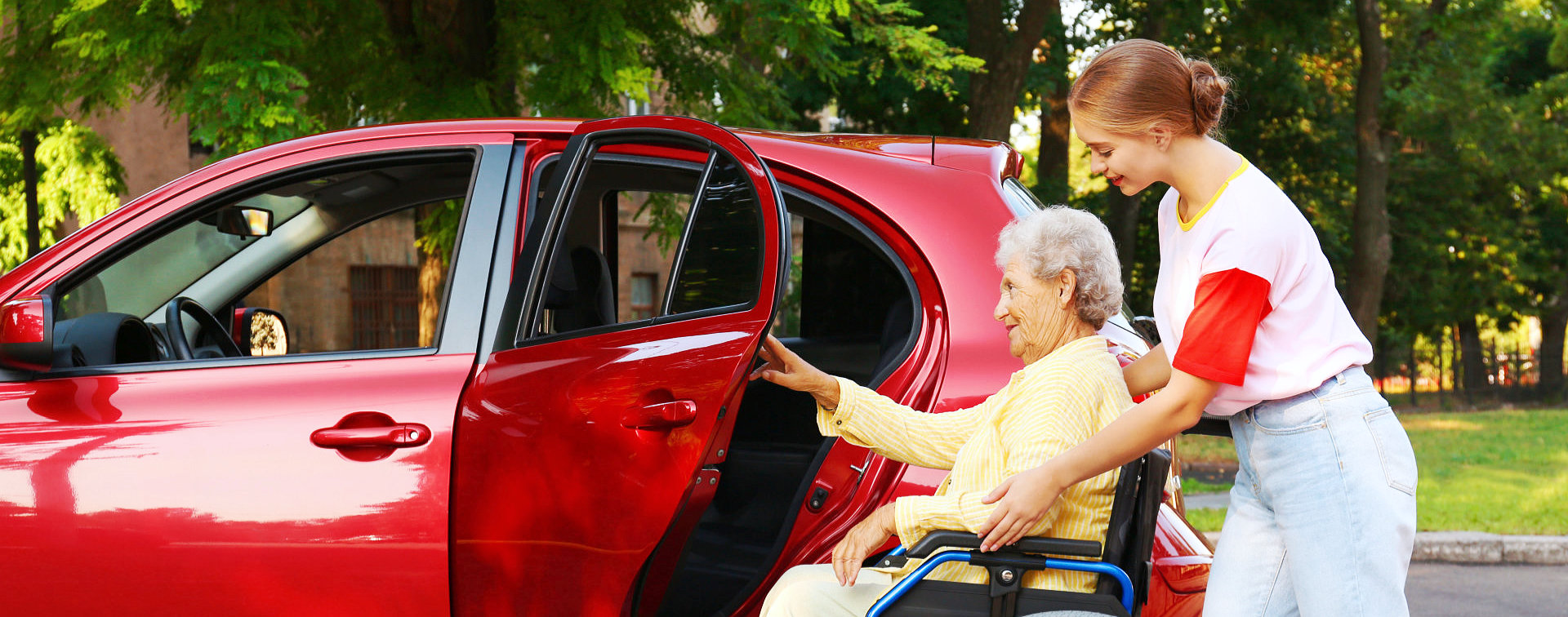 caregiver helping senior woman get in the car